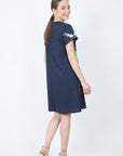 Back view of model wearing the Fanm Mon Gence Dress in navy showing the clean back, short sleeves, and softly flared mini silhouette
