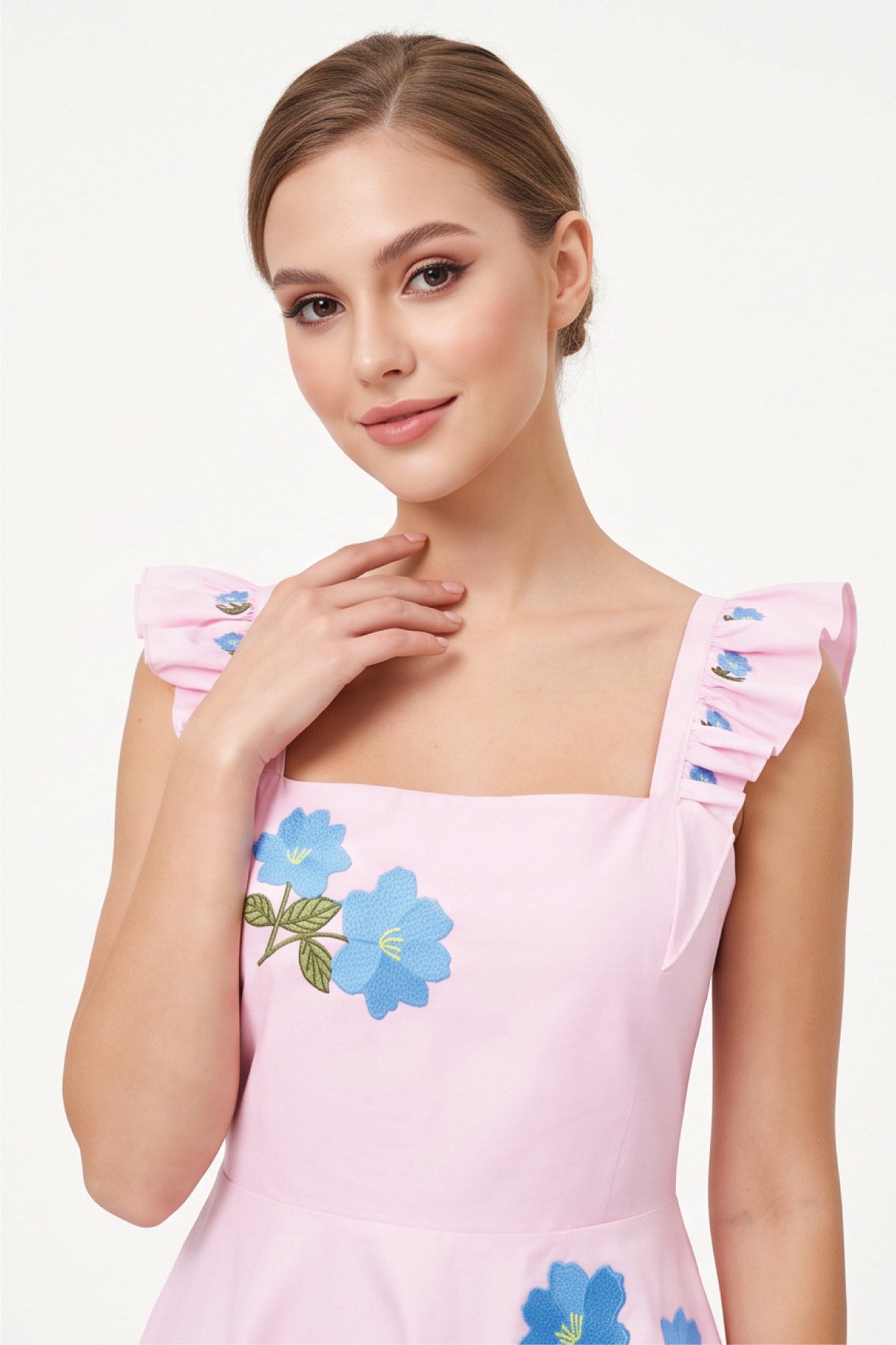 Detail of model wearing the Fanm Mon Hype Dress with blue floral embroidery and ruffled shoulder straps.