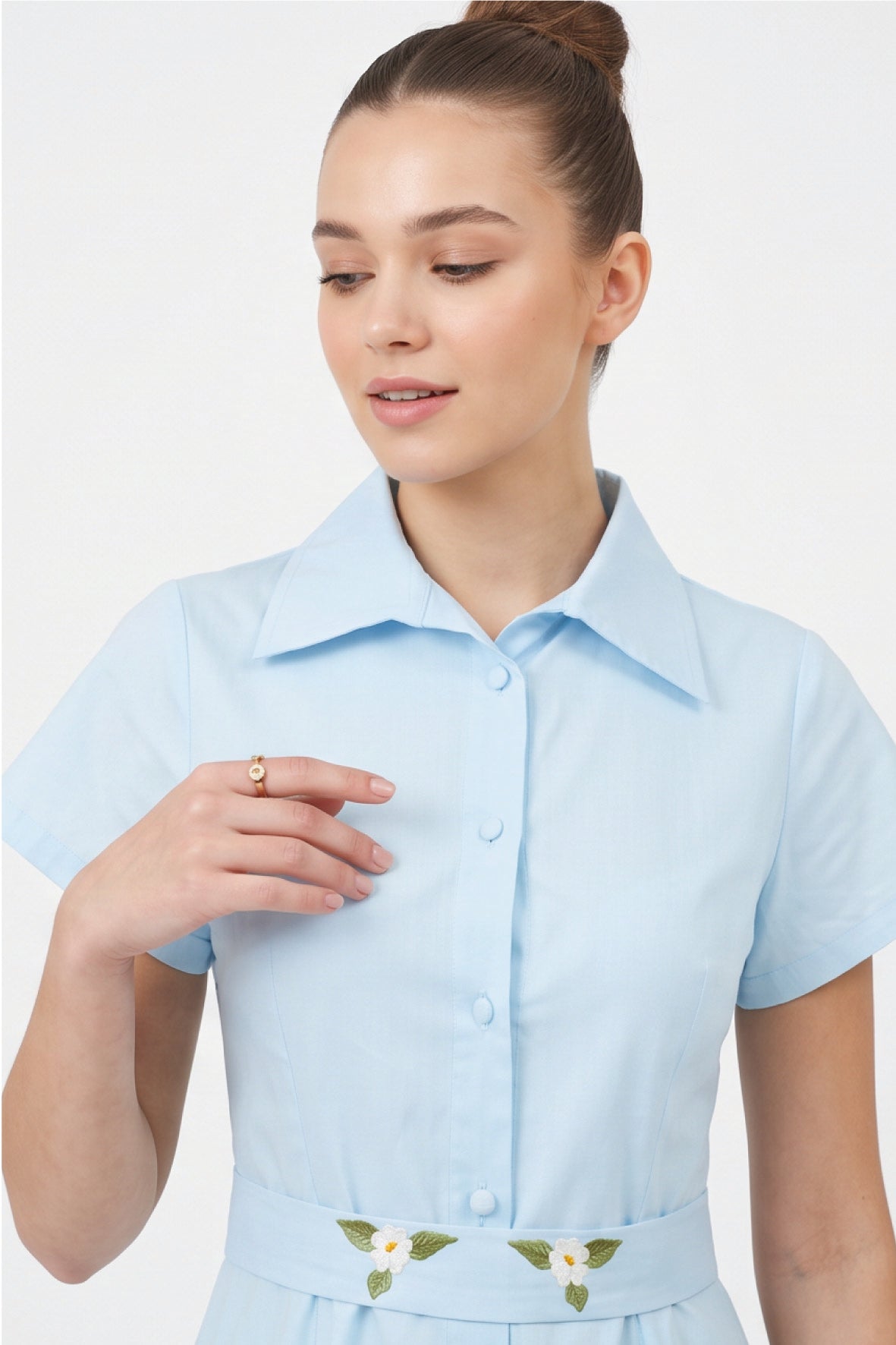 Close-up of Fanm Mon Jahan Dress in light blue showing the tailored collar, fabric-covered buttons, and delicate white floral embroidery on the waist belt