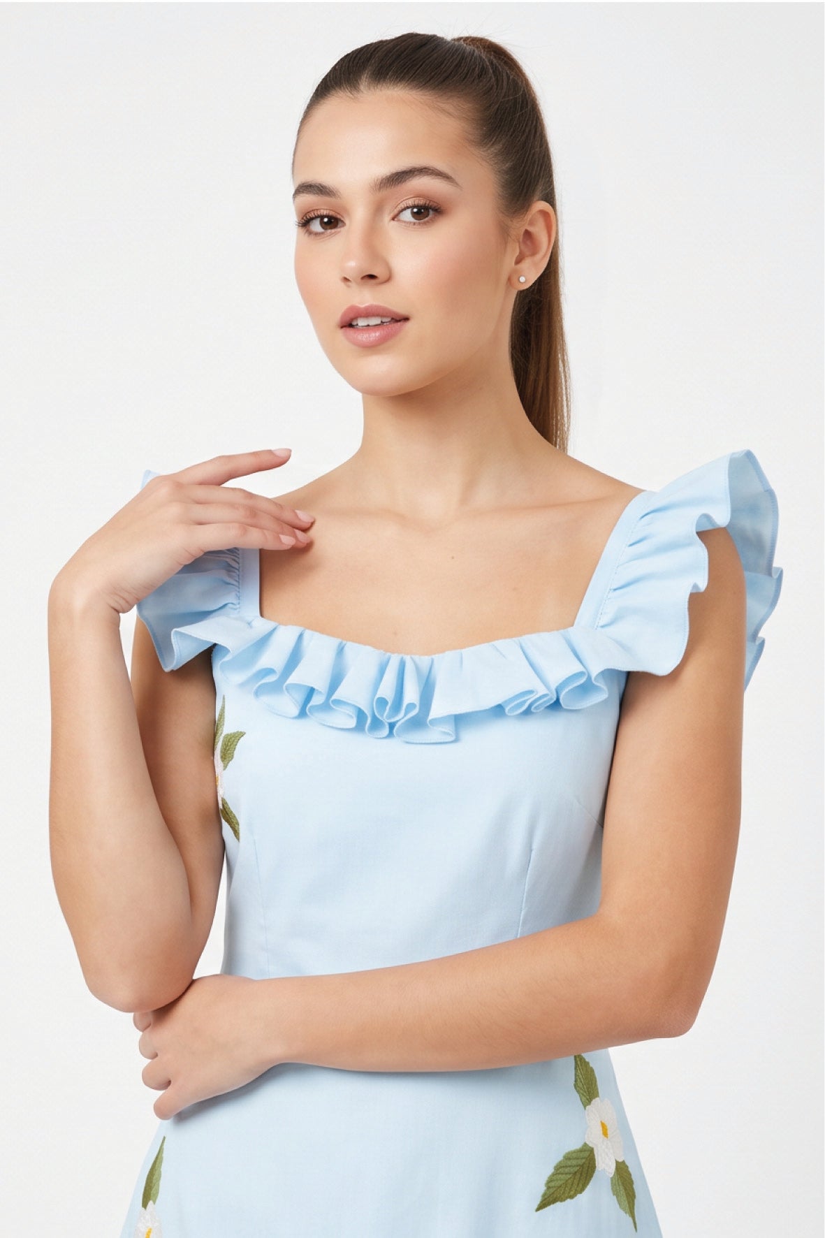 Close-up of Fanm Mon July Dress in light blue featuring a ruffled square neckline, flutter sleeves, and delicate white floral embroidery