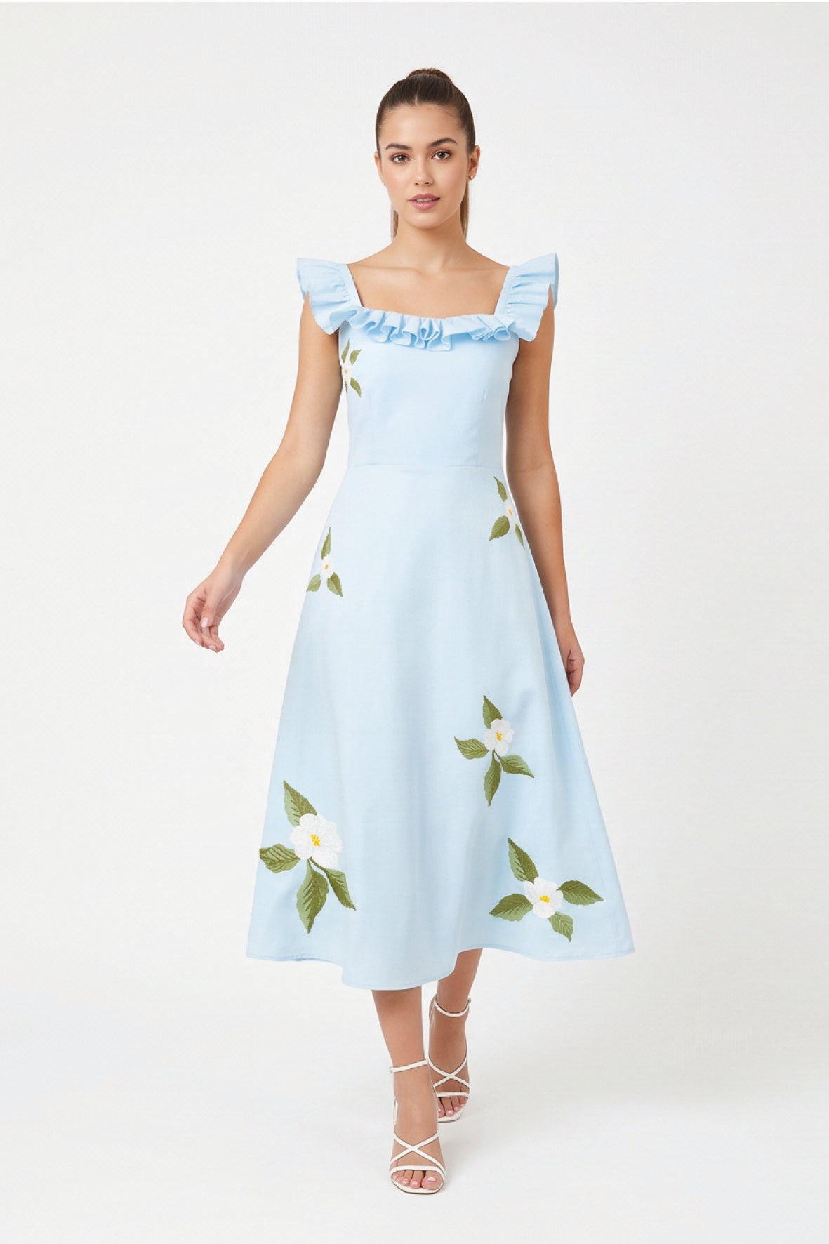 Model wearing Fanm Mon July Dress in light blue with ruffled shoulder straps, white floral embroidery, and a flowing A-line midi skirt