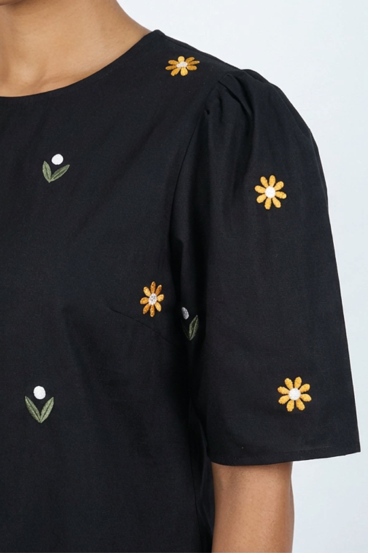 Detail of Fanm Mon Kehribar Top in black with golden yellow and white daisy floral embroidery and gathered sleeve