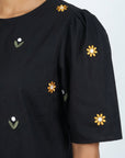 Detail of Fanm Mon Kehribar Top in black with golden yellow and white daisy floral embroidery and gathered sleeve