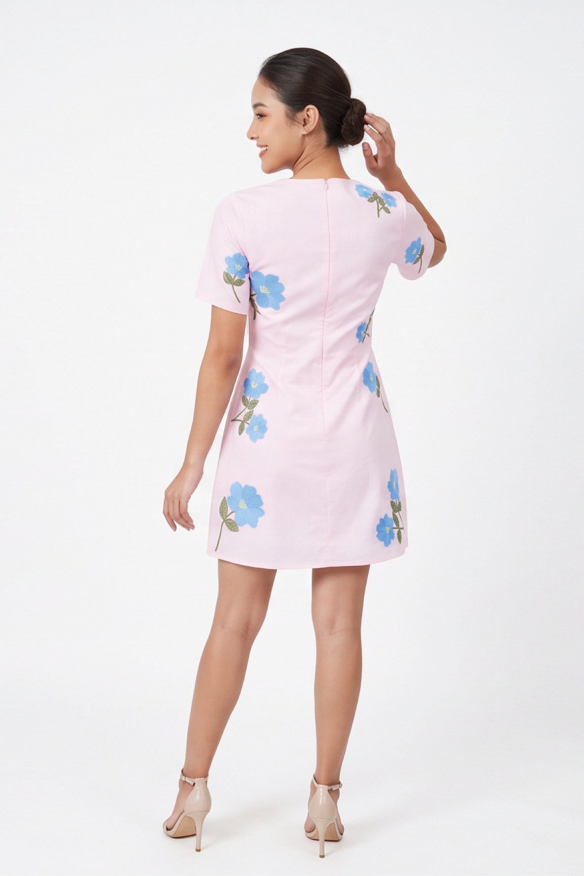 Back view of model wearing the Fanm Mon Kore Dress with blue floral embroidery and a concealed back zipper.