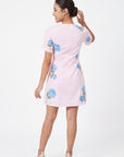 Back view of model wearing the Fanm Mon Kore Dress with blue floral embroidery and a concealed back zipper.
