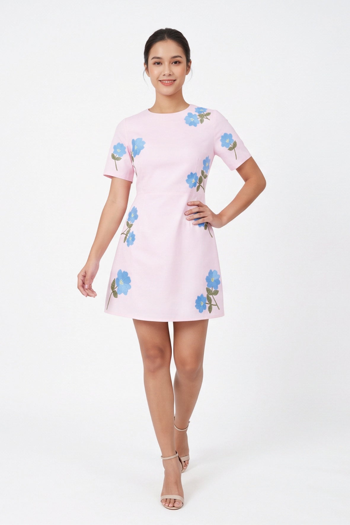 Model wearing the Fanm Mon Kore Dress with vivid blue floral embroidery, short sleeves and an A-line mini silhouette.