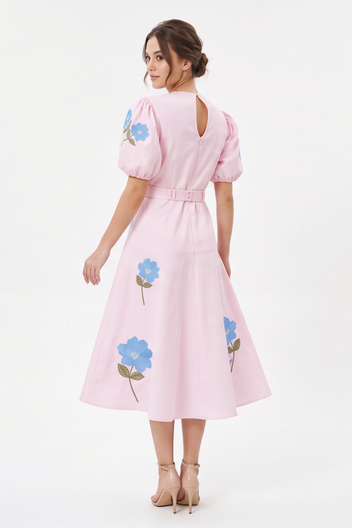 Back view of model wearing the Fanm Mon Lare Dress with puff sleeves, blue floral embroidery and a keyhole back.