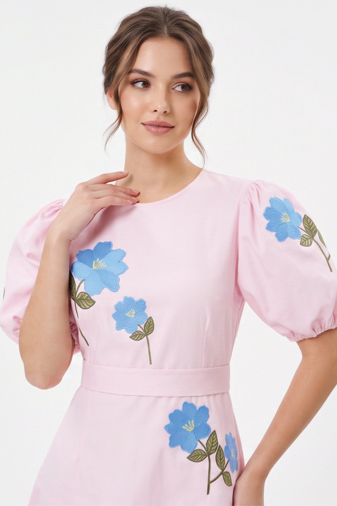 Detail of model wearing the Fanm Mon Lare Dress with blue floral embroidery and voluminous short puff sleeves.