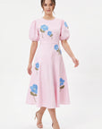Model wearing the Fanm Mon Lare Dress with blue floral embroidery, puff sleeves and a defined A-line midi silhouette.