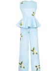 Fanm Mon Malez Set in Light Lagoon featuring a fitted sleeveless peplum top and coordinating wide-leg trousers with asymmetrically placed white floral embroidery and green botanical detailing