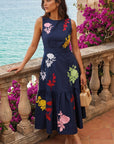 Model wearing the Fanm Mon Mihrap Dress with colorful floral embroidery and a tiered midi skirt