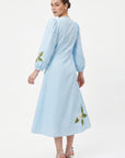 Back view of model wearing the Fanm Mon Paysan Dress in light blue with a defined waist, puff sleeves, and floral embroidery