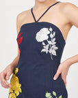 Detail of Fanm Mon Pout Dress featuring white and red floral embroidery and crossover neckline straps