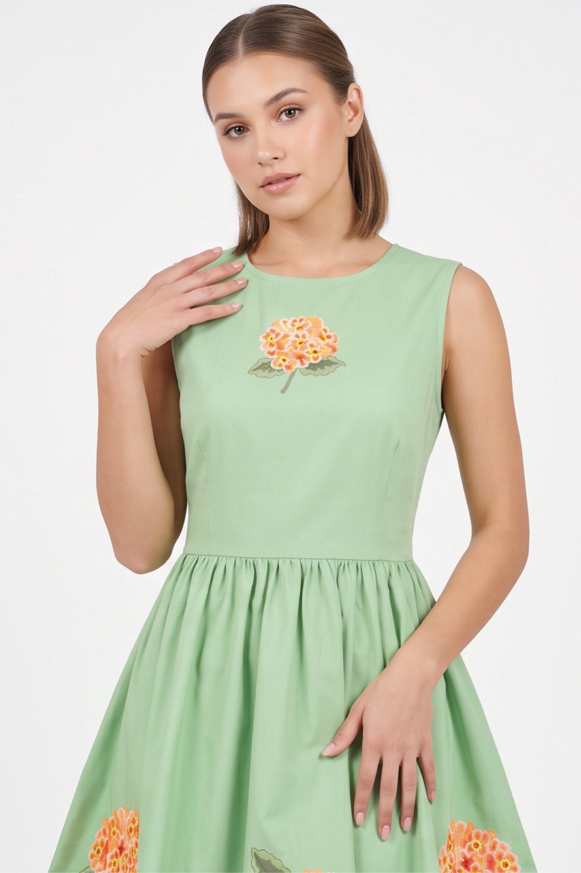 Detail of the Fanm Mon Seher Dress featuring orange floral embroidery at the bodice and a round neckline.