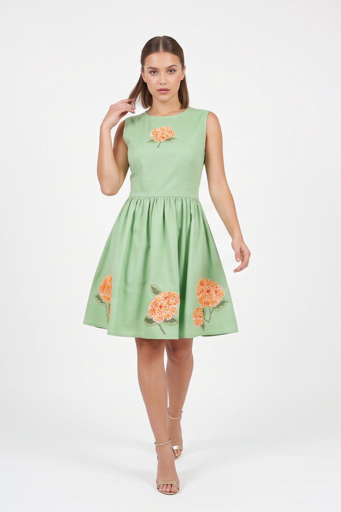Model wearing the Fanm Mon Seher Dress with orange floral embroidery, a fitted sleeveless bodice and gathered mini skirt.