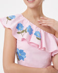 Close-up of the Fanm Mon Tamira Set highlighting the one-shoulder ruffled neckline and delicate blue floral embroidery with yellow centers and green leaves