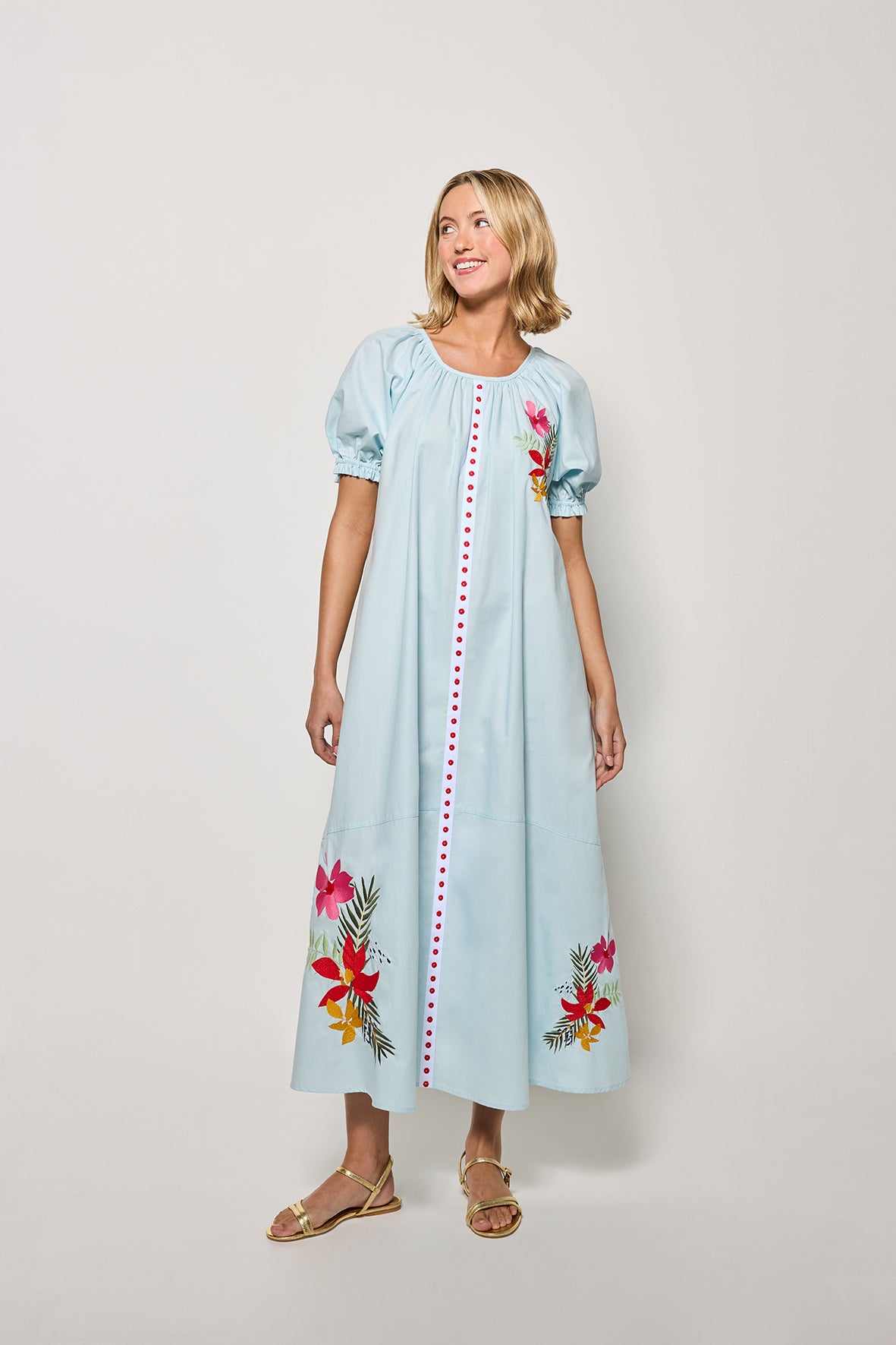 Model wearing the Evora dress in Light Lagoon with floral embroidery on a white background 
