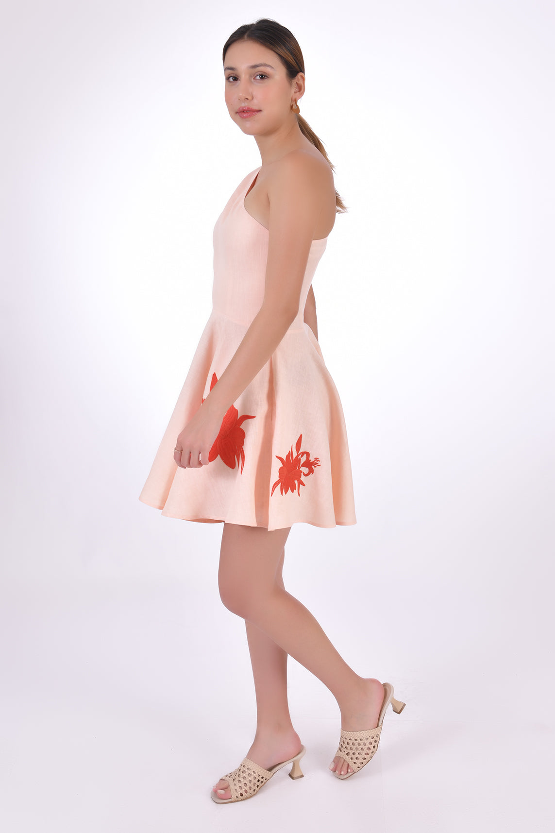 Fanm Mon Eftelya Linen Dress (Side View without Bow). Mini One Shoulder Linen Dress with a full circle skirt, detachable bow detail, hidden side zipper, and embroidery on the skirt.